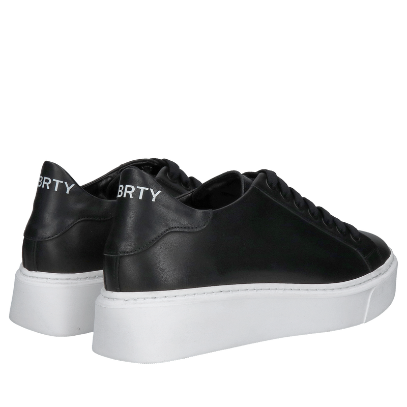 Modne czarne sneakersy ze skóry licowej na białej grubej podeszwie